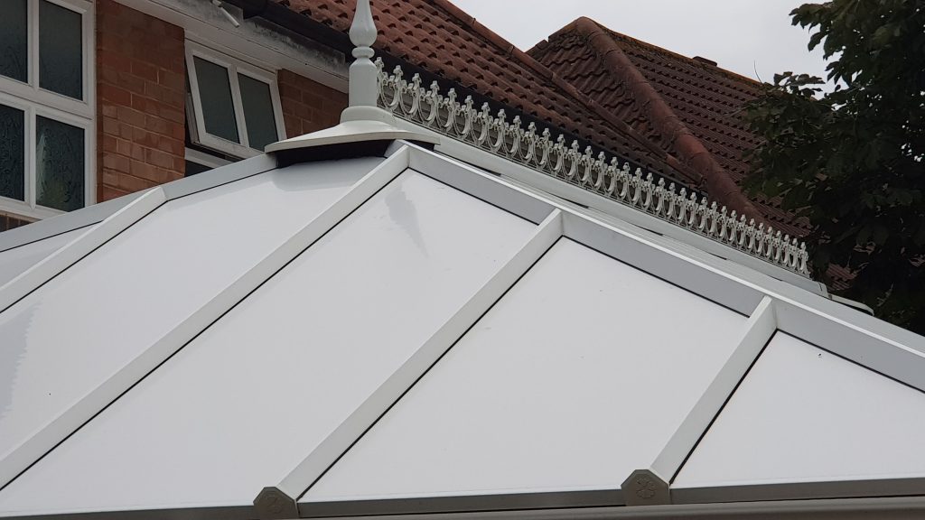 a white roof with a red brick building in the background.
